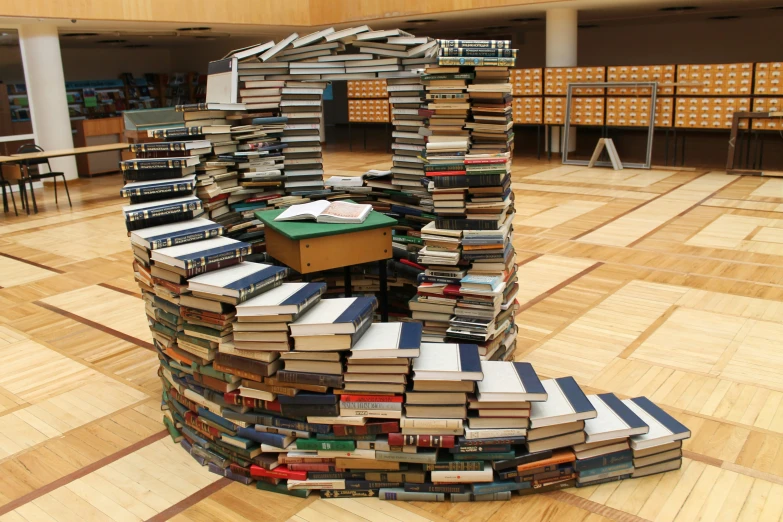 a desk made out of books is displayed in a room