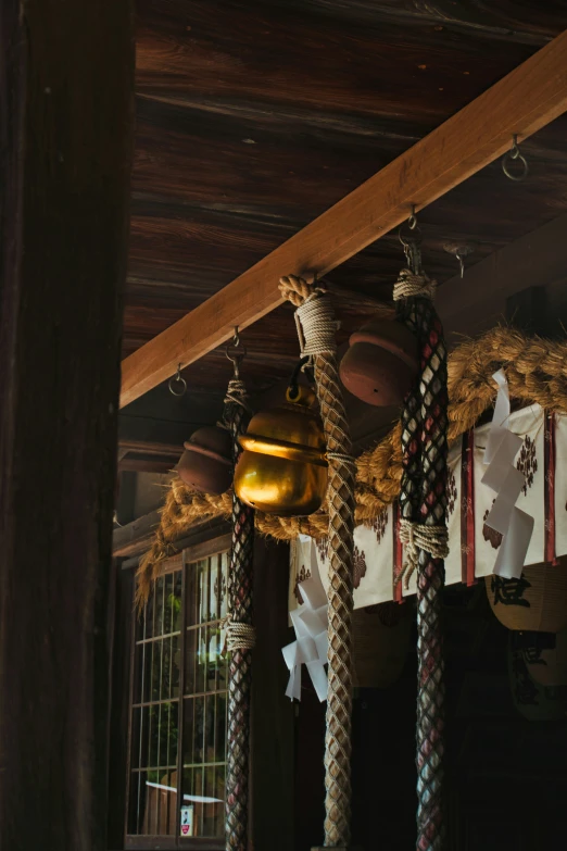 the bells are hanging on the wood beam