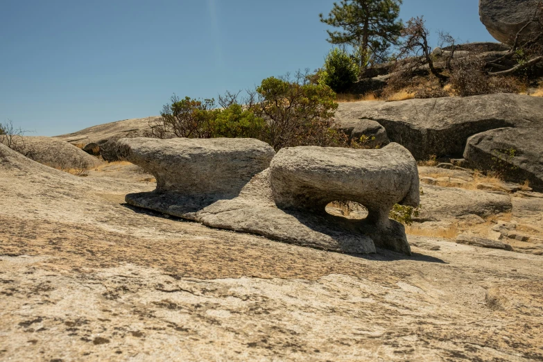 a pair of large rocks sitting on top of a sandy beach