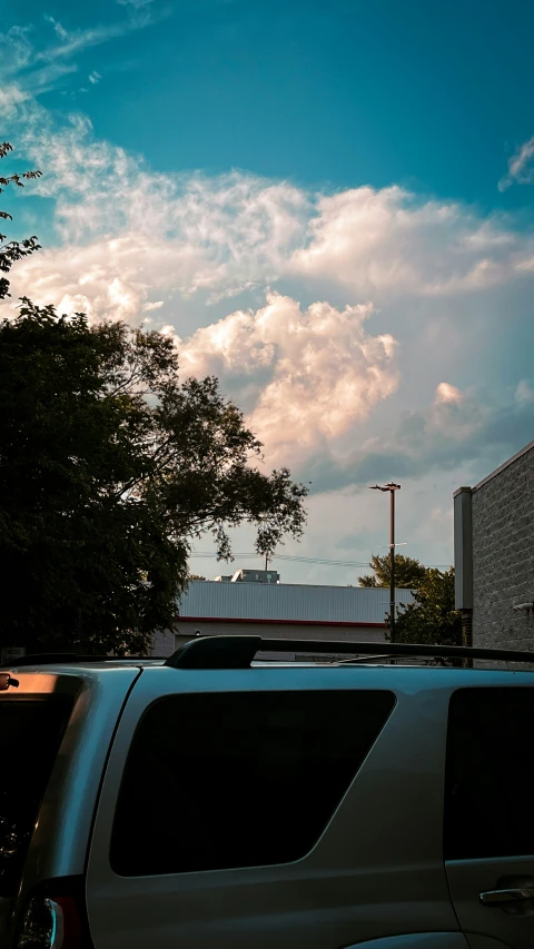 cars on the road near a building and trees