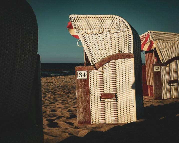 a couple of white beach huts sitting on top of a sandy beach