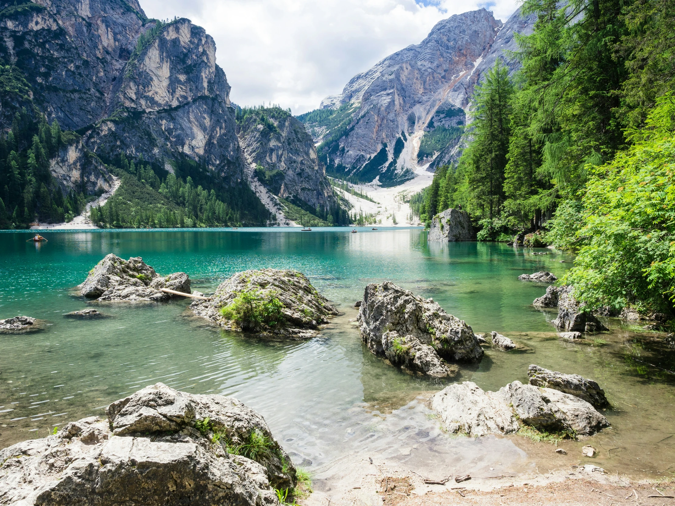 some rocks are in the water near some mountains