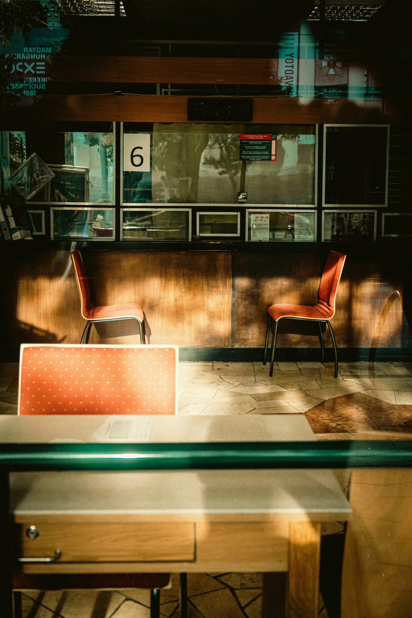 some tables and chairs sitting by a large window