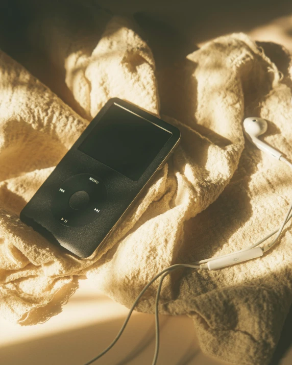 an old mp3 player lays on a blanket