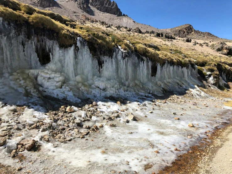 ice is hanging off the side of a hill side