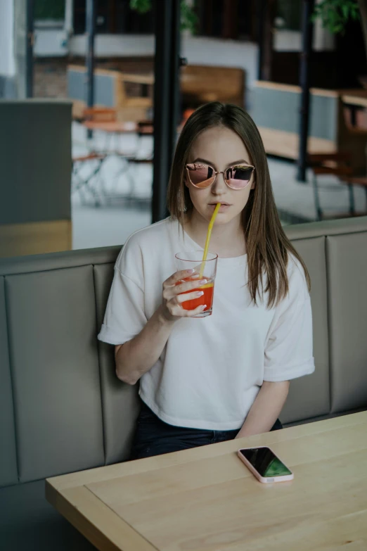 woman with a straw drinking from a glass