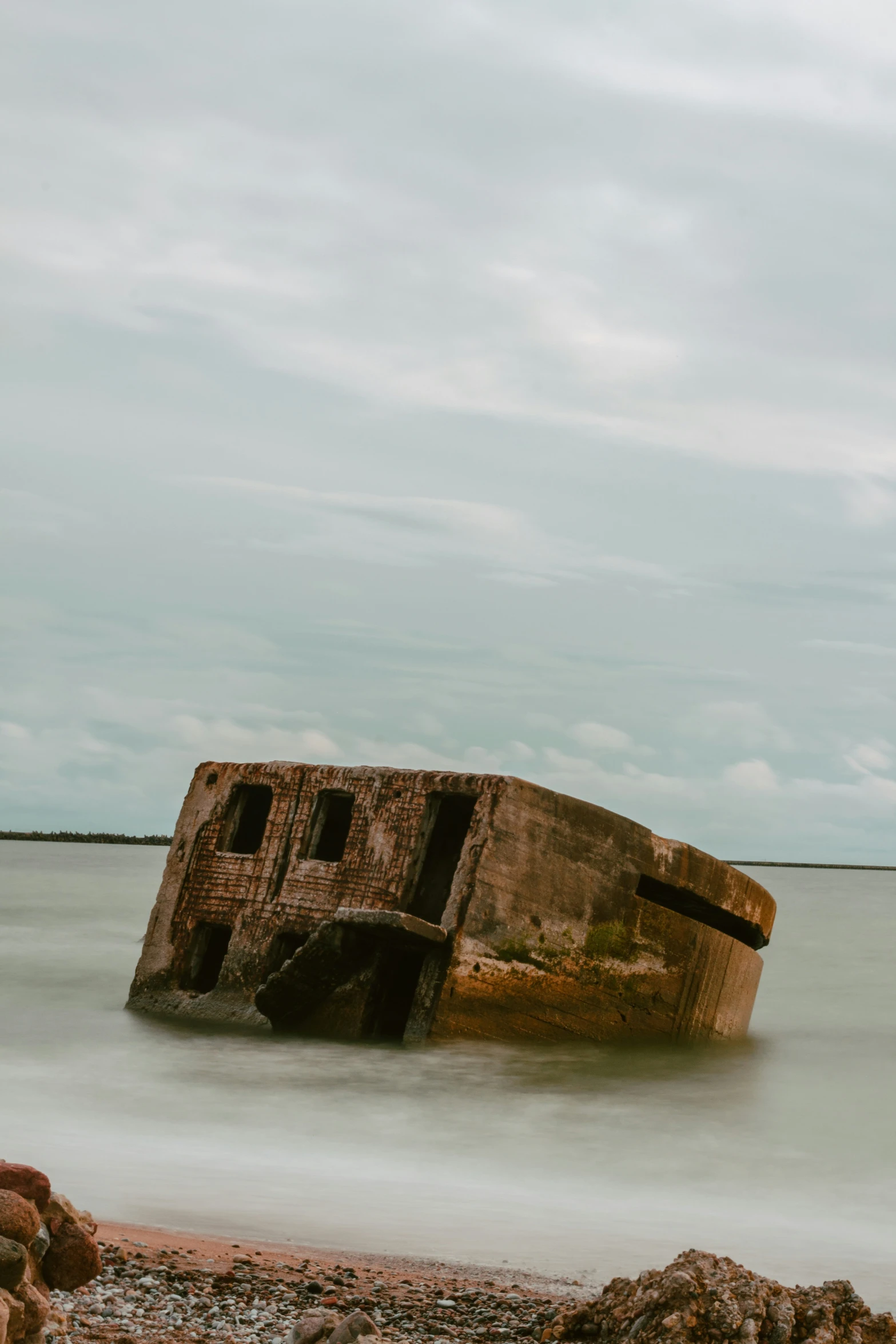 an old brick structure sitting on top of the beach