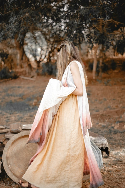 a person dressed in traditional clothing walking through the woods