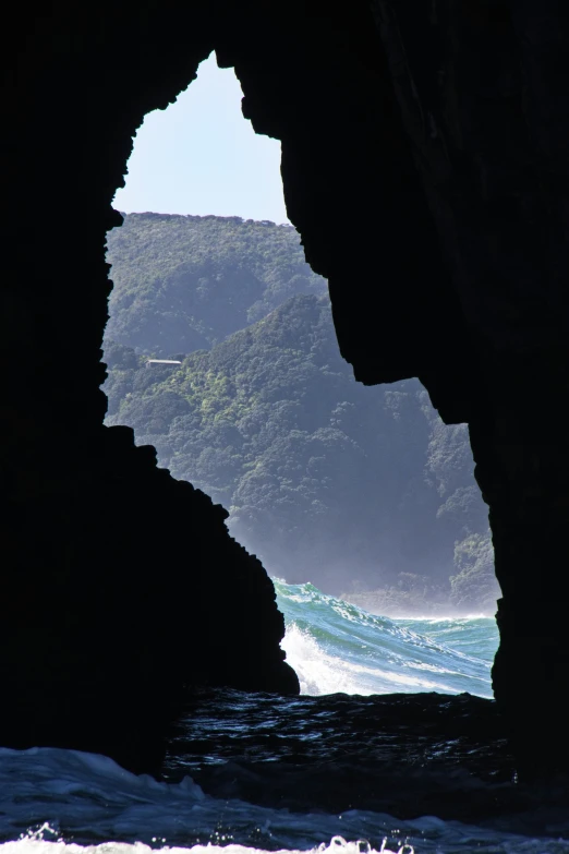 a cave opening shows the ocean as if a wave has broken and crashed