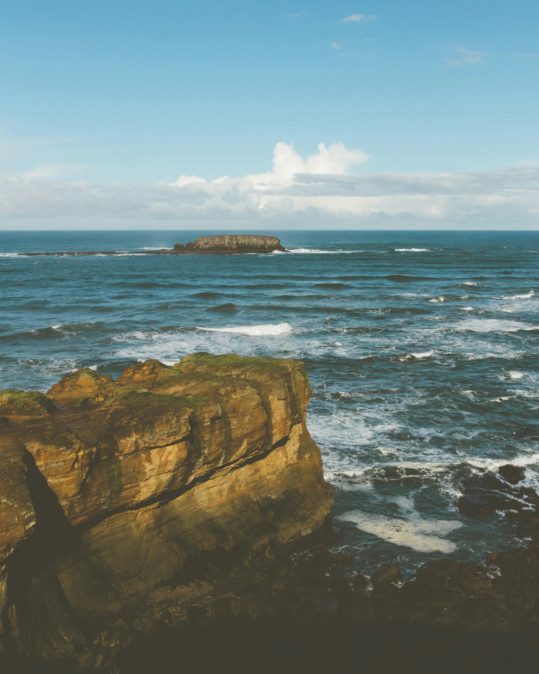 a large rock sticking out of the ocean