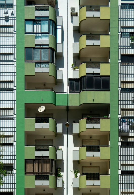 a tall building has a few balconies and many windows