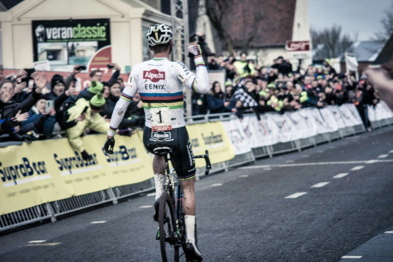 a man on a bicycle on the street in front of a crowd