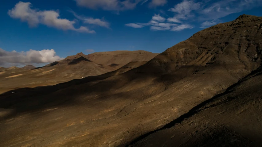 mountains covered with brown sand under a blue sky