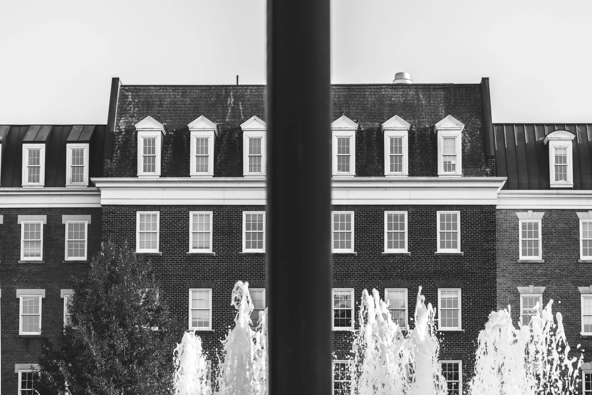 a black and white po of a building with water jets in front