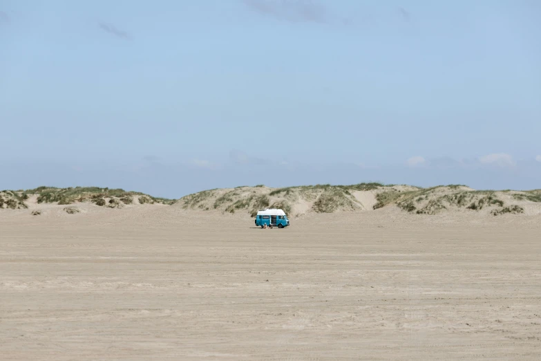 an empty beach next to sand dunes