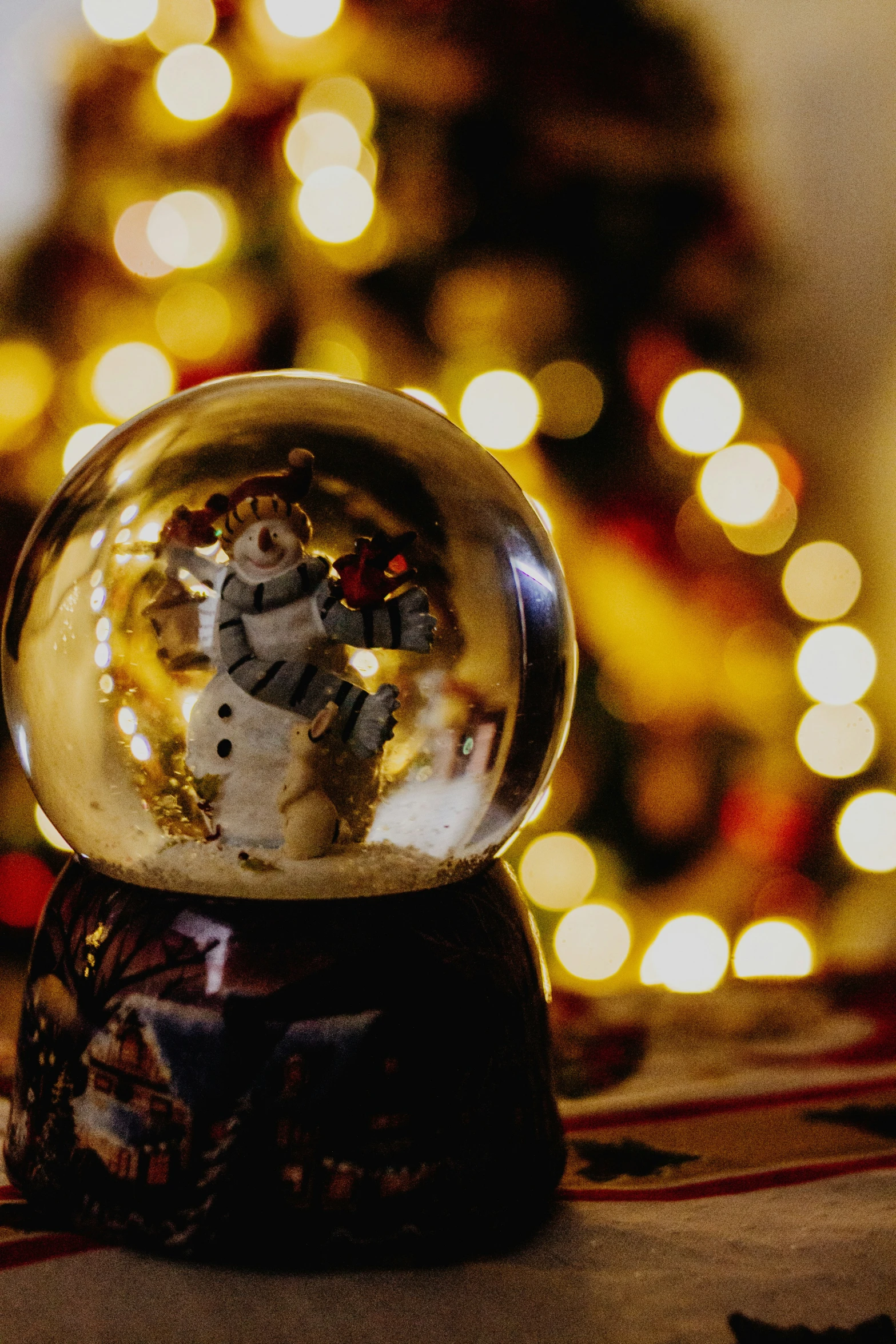 a snowman is sitting in the center of a glass ball