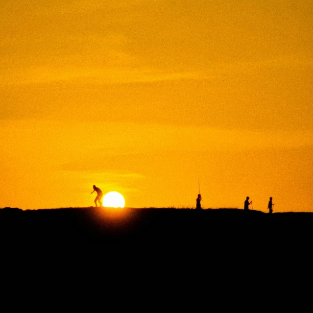 a group of people standing on top of a mountain in the sun