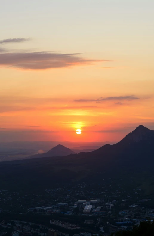 a bird flying over a beautiful view of mountains and sunset