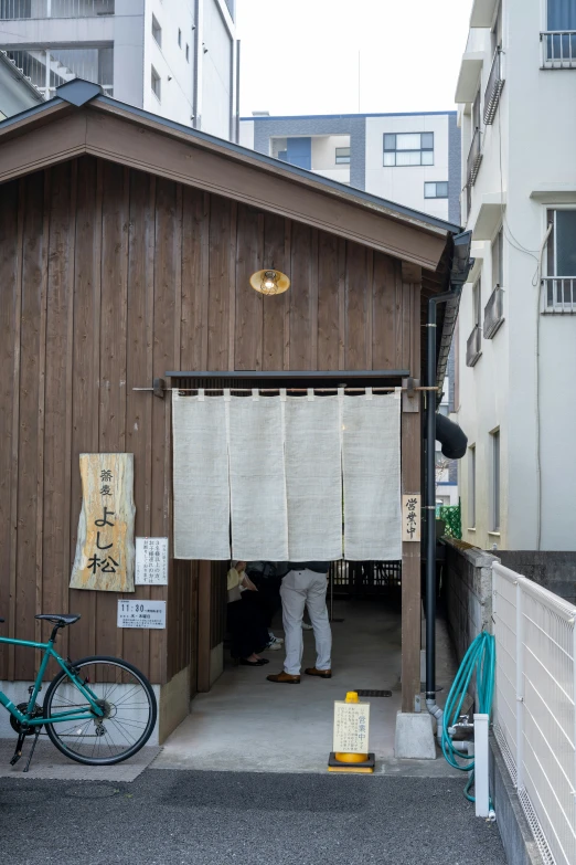 a small building with a man putting soing in it