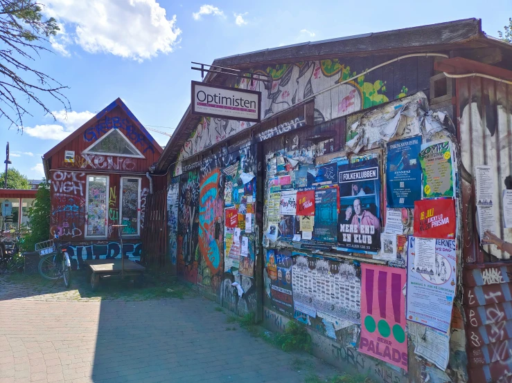 a wall with many pictures on it and a road next to it