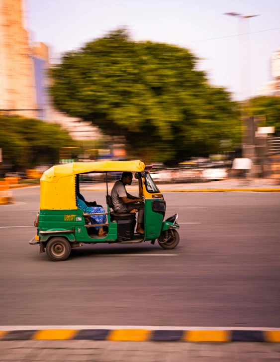 a green and yellow four wheeler on the road