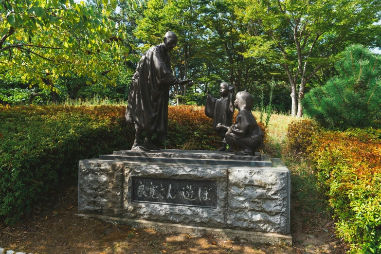 the statues have been placed in a small group near trees