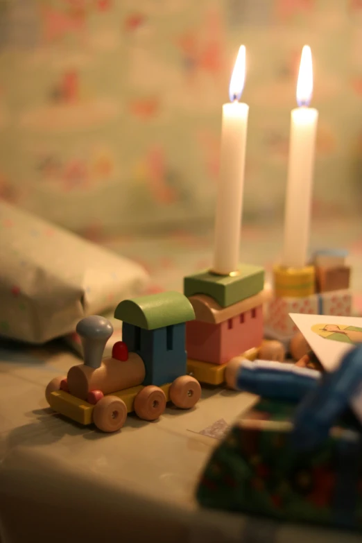 a close up of candles on a table with a train