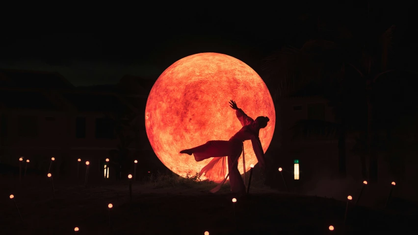 a man standing in front of a giant full moon