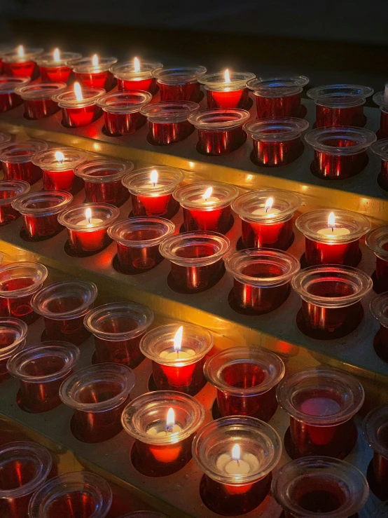 many lit candles and plates sit on a table