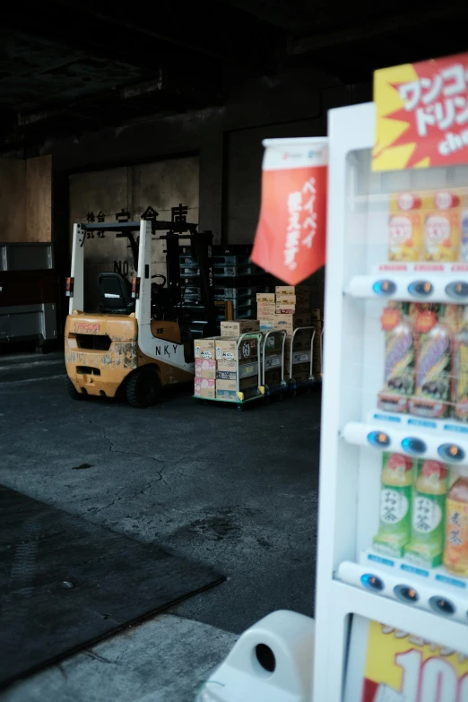 a white small forklift carrying drinks into a storage area
