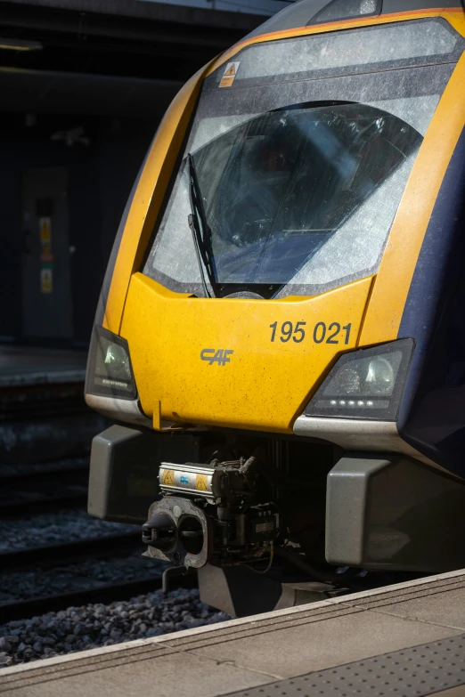 there is a yellow and blue train at the station