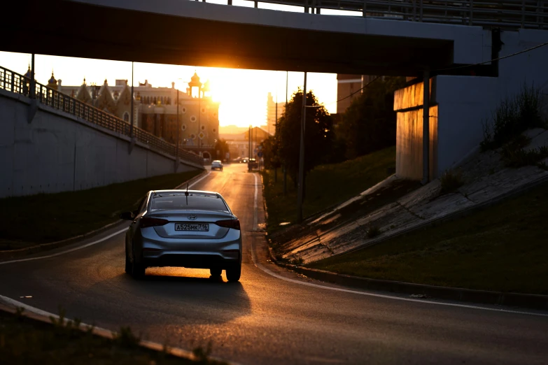 a car is going down the road at sunset