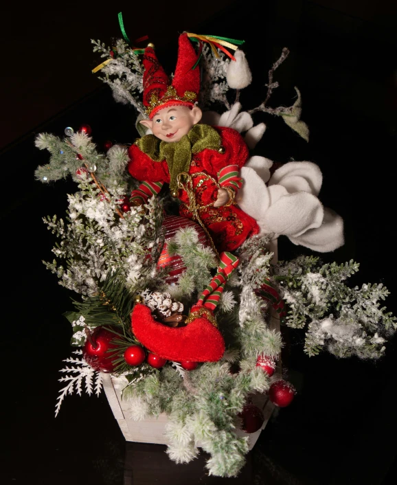 a red gnome statue sitting in a christmas bouquet