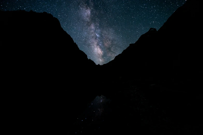the night sky shows the milky and mountains