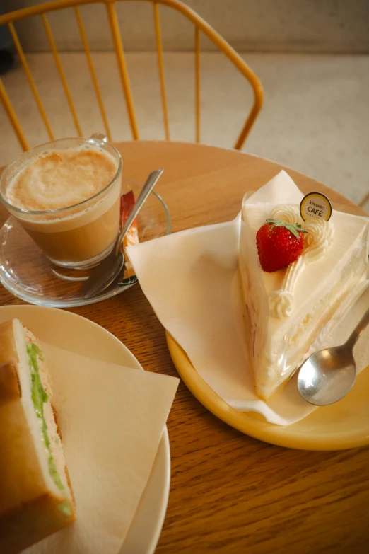 a piece of cake sitting on top of a white plate next to a cup of coffee