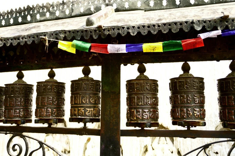 five ss bells with colorful strings hanging from them