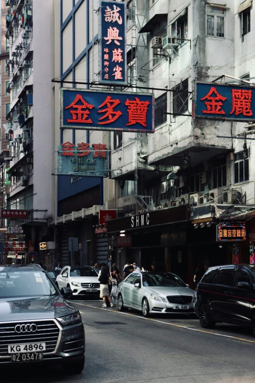 cars traveling down the street near tall buildings