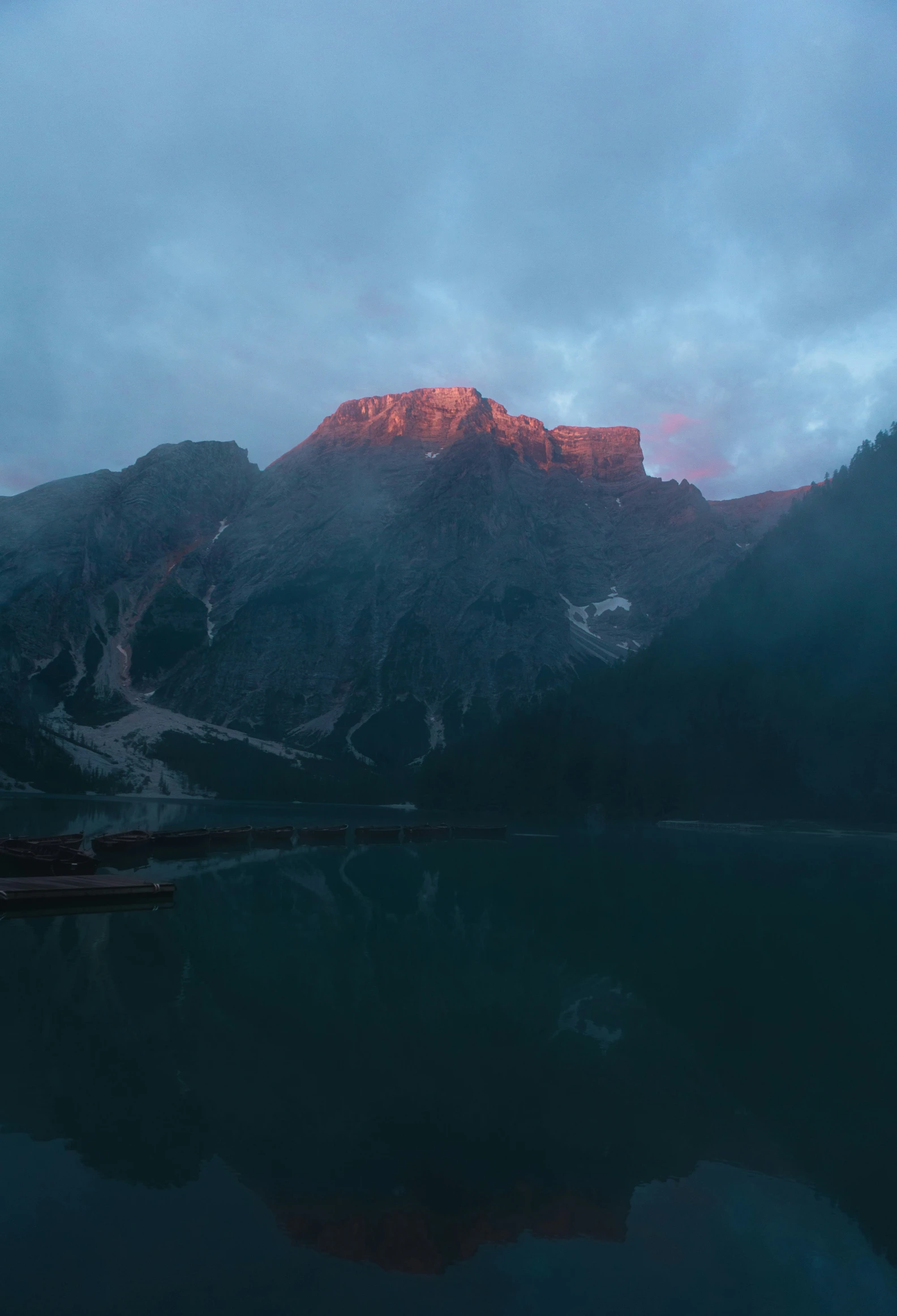 a mountain with red and white lights reflecting in the water