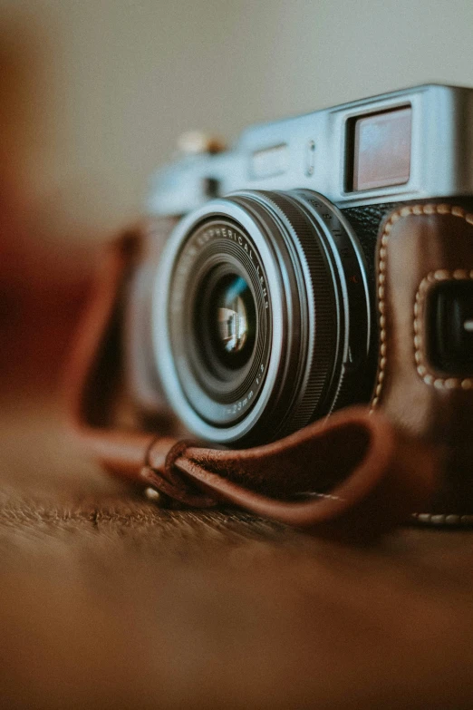 the back of an old camera sitting on a leather case