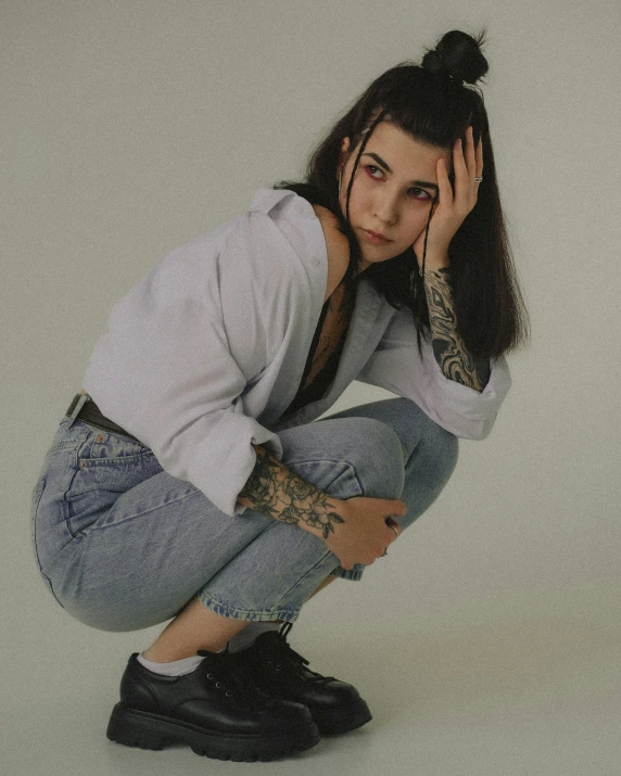 a girl squatted on the ground while posing for a picture