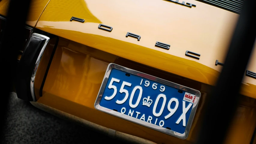 an antique yellow porsche plate that is on display
