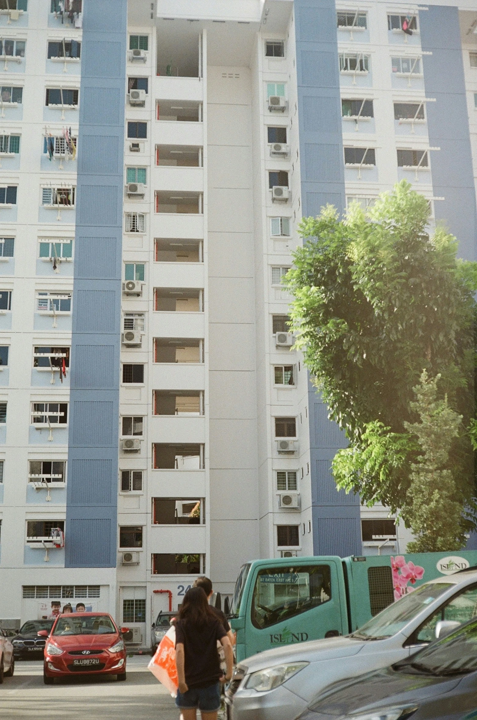 two women on bicycles outside of a tall blue and white building