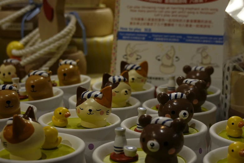 several small, rubber animal heads are displayed in cups