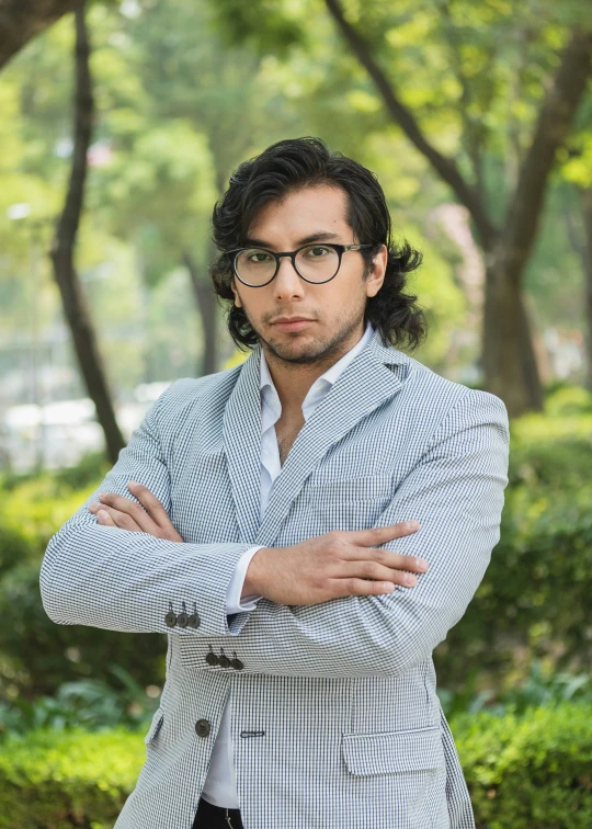 a man with his arms crossed in a park