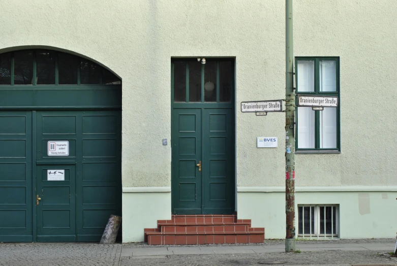 the exterior view of the building with two green doors