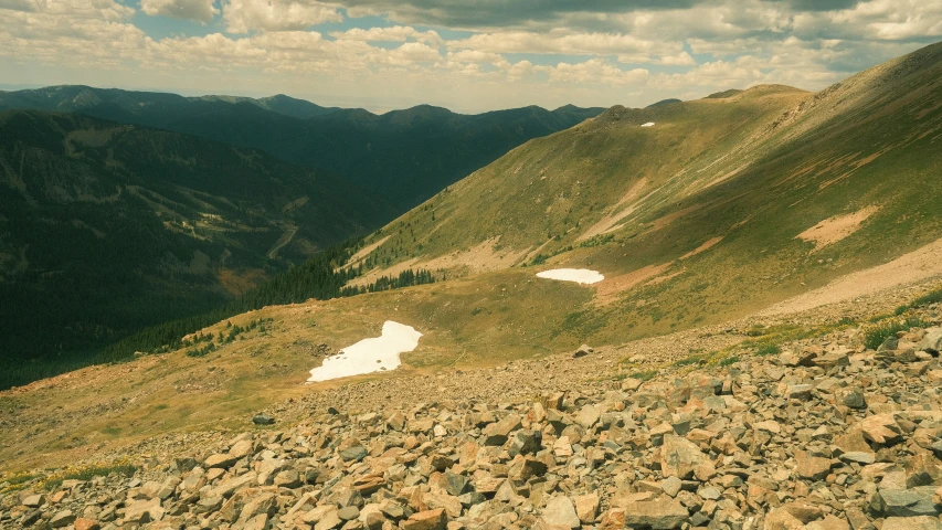 two hikers on a hill taking in the view from atop a mountain