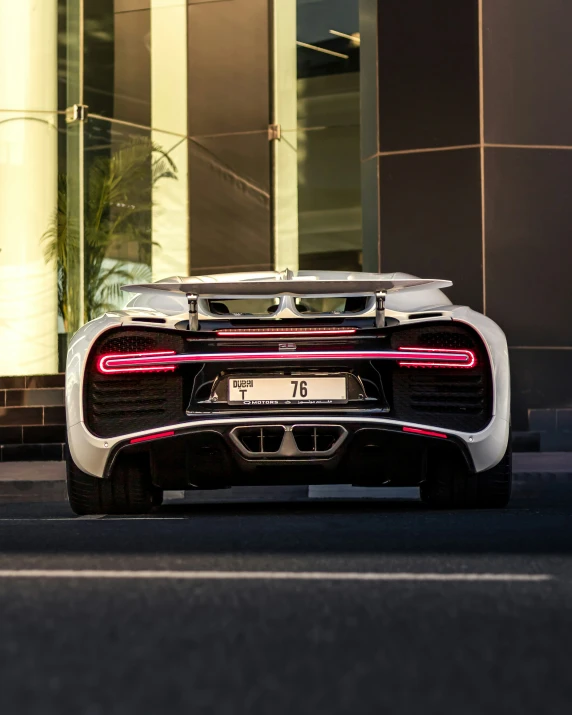 a silver sports car parked in front of a building