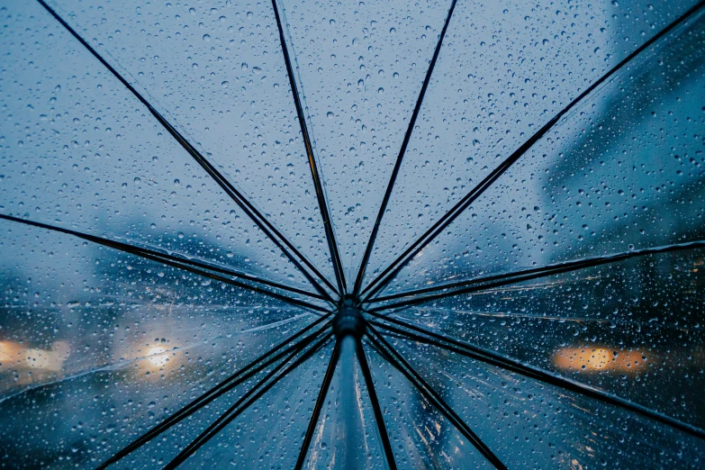 an open umbrella sitting on a rain covered window