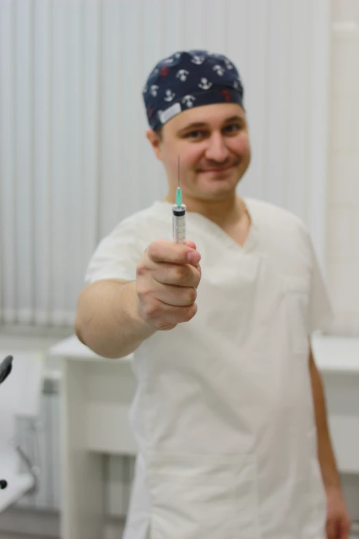 a man in white shirt holding up a small toothbrush