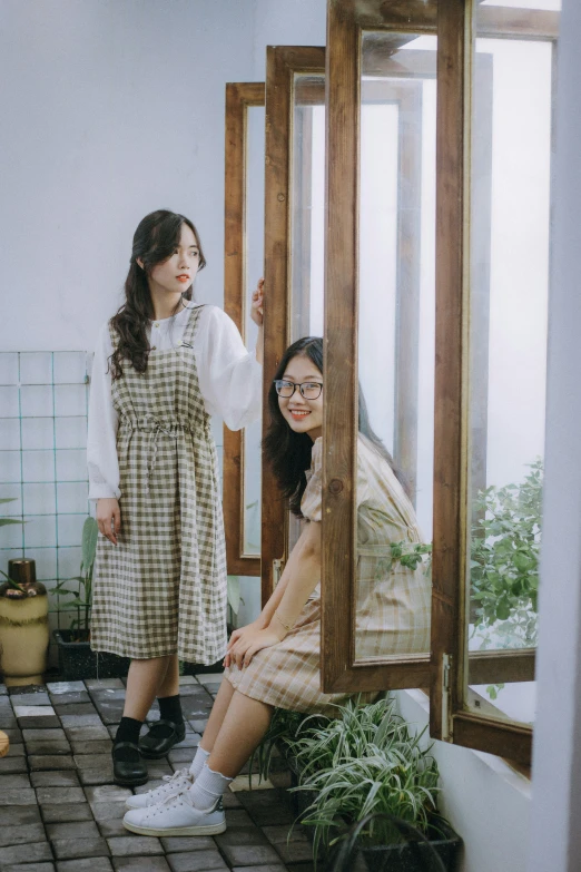 two asian women are looking into the mirror